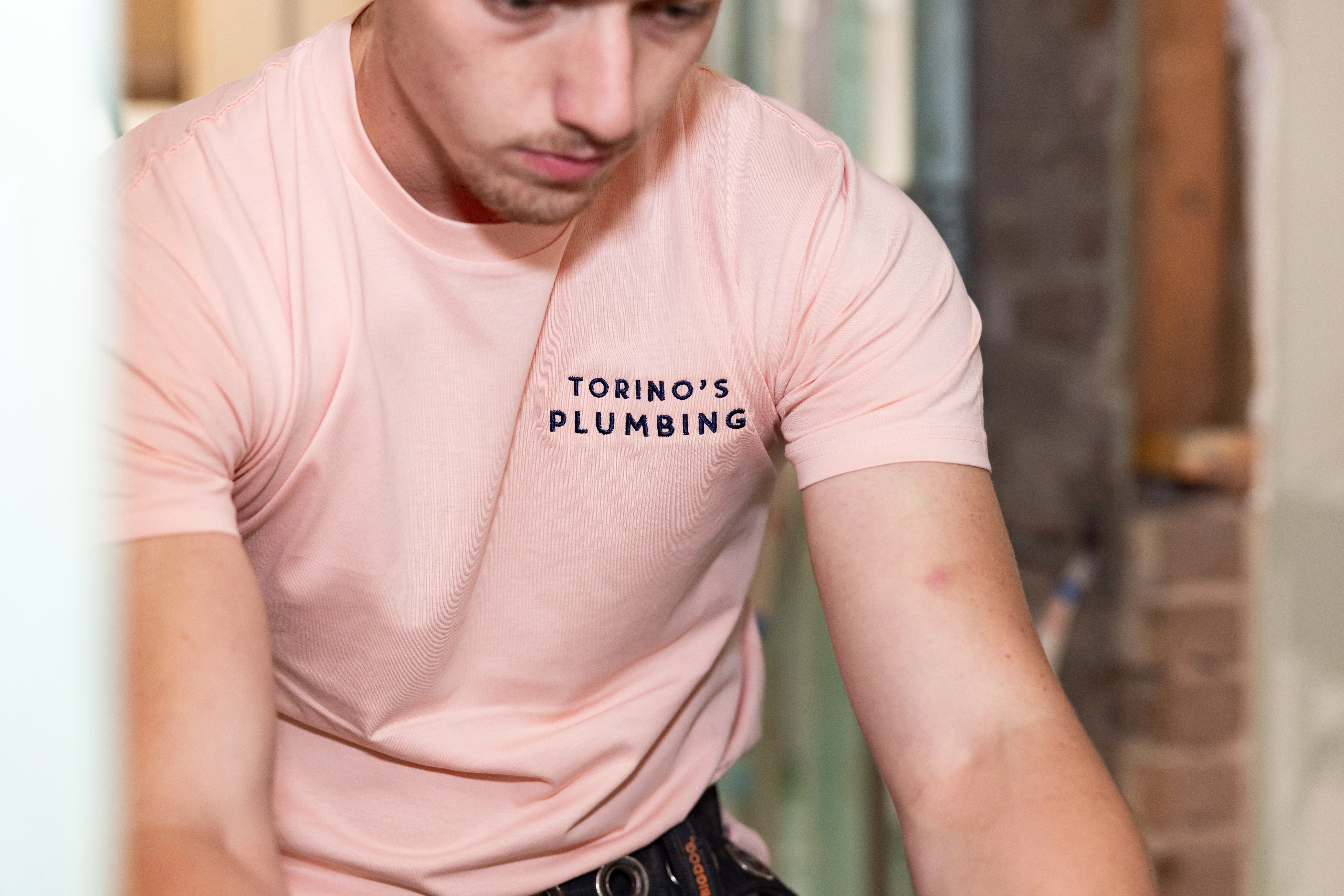 Plumber inspecting a toilet for leaks