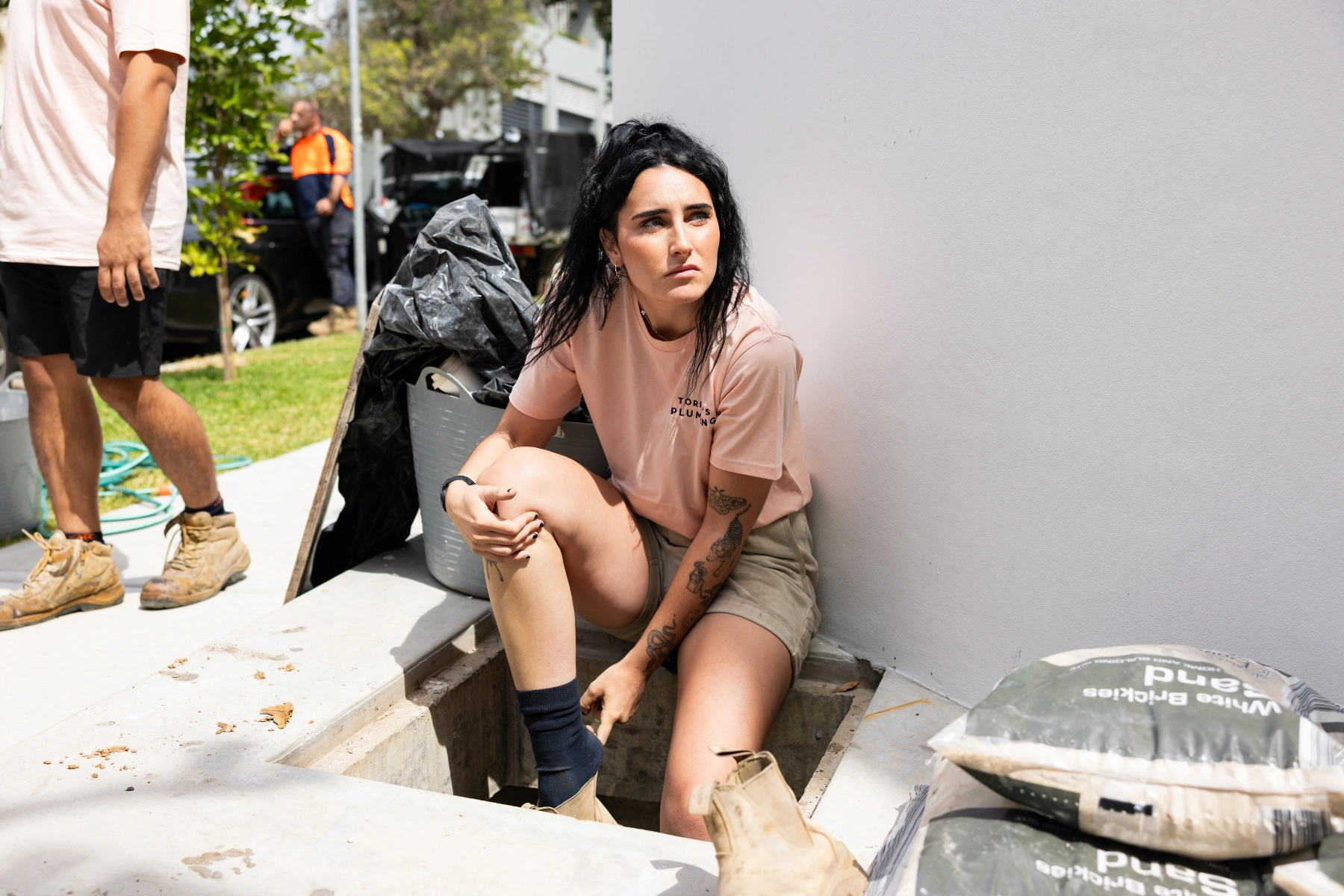 Torino's Plumbing - Woman Plumber taking off boots
